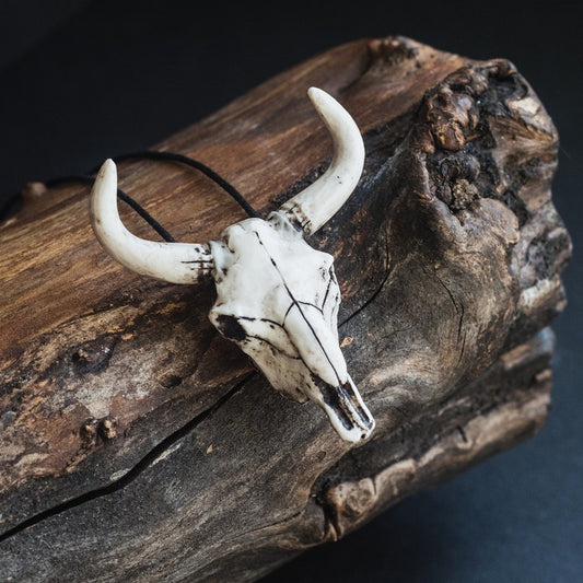 Bull skull pendant with horns on wooden background